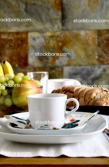 Breakfast table with a coffee mug and fruits.