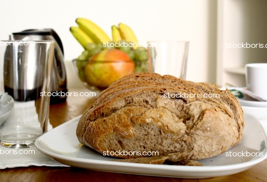 Breakfast table with bread, bananas, grapes and papaya