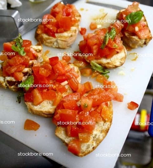 Bruschettas being prepared over a white cutting board