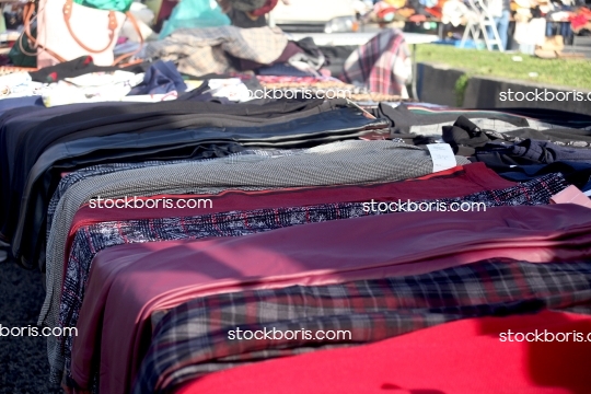 Fabrics at a market. Red, blue and black fabrics.