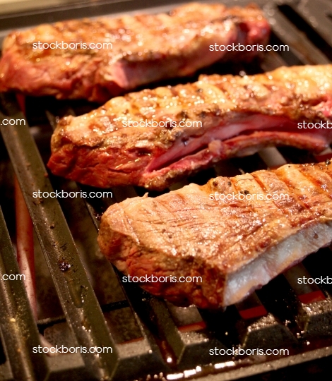 Grilling steak meat beef on an electric barbecue.