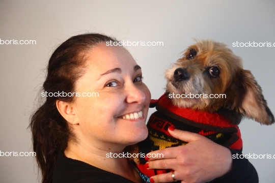 Happy smiling woman with her dog in her arms.