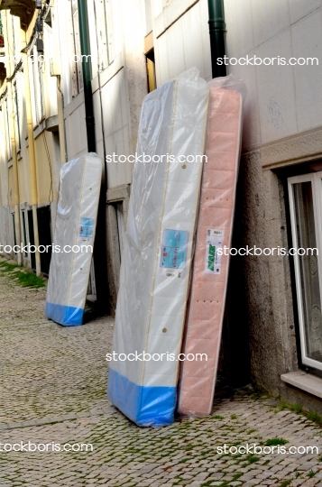 Mattresses in front of a building. Moving in.