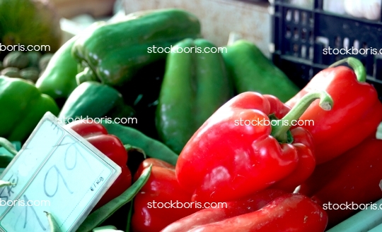 Red peppers and green peppers at a market.