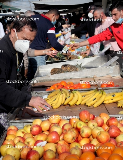 Senior man buying fruits at a market. Bananas, apples.