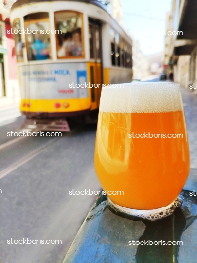 Tram 28 in Lisbon, in 2020, and a hazy craft beer glass in front of it.