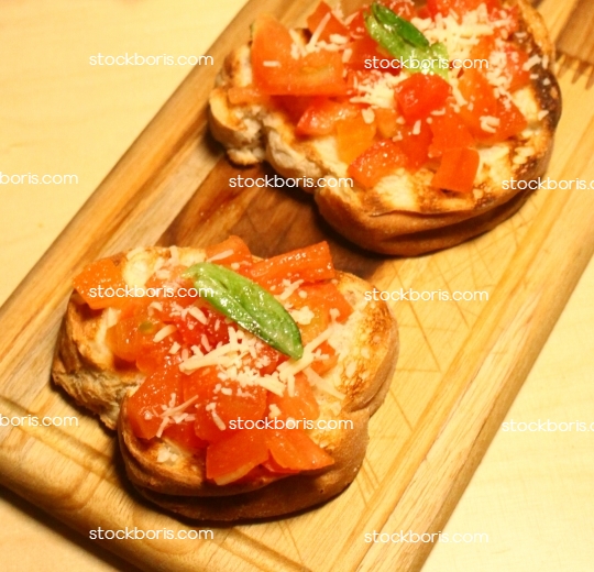 Two bruschettas over a wood board